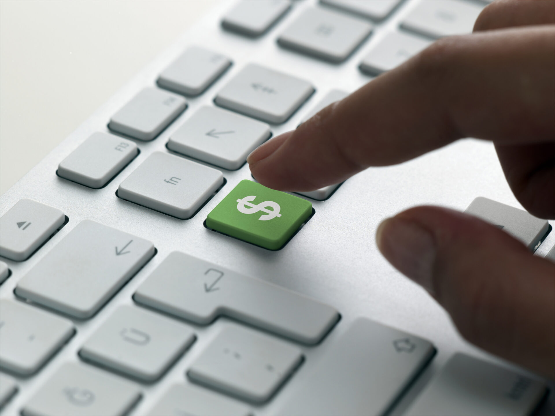 finger about to press a green dollar sign key on a pc keyboard